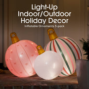 Three inflatable holiday ornaments on a table with text indicating they are light-up indoor/outdoor decor.